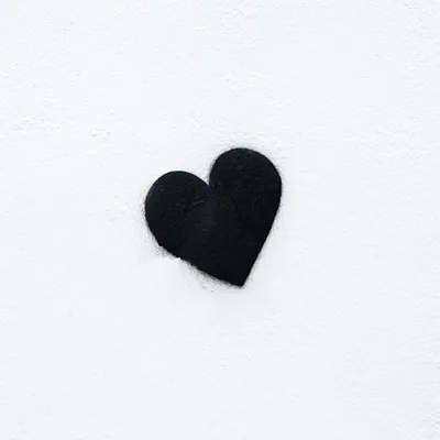 A fuzzy fabric heart sits a little left of centre on an off-white square, its faint shadow falling straight down, wide empty margins ready for icons.