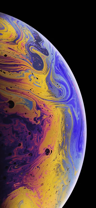 Yellow, blue and purple currents swirl across a soap-film planet freckled with dark spots, black surviving only in the upper right corner.