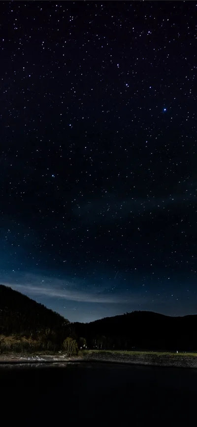 Sparse stars over black hills and still water in this tall frame — the bottom third is almost pure black, handy for phone dock icons.