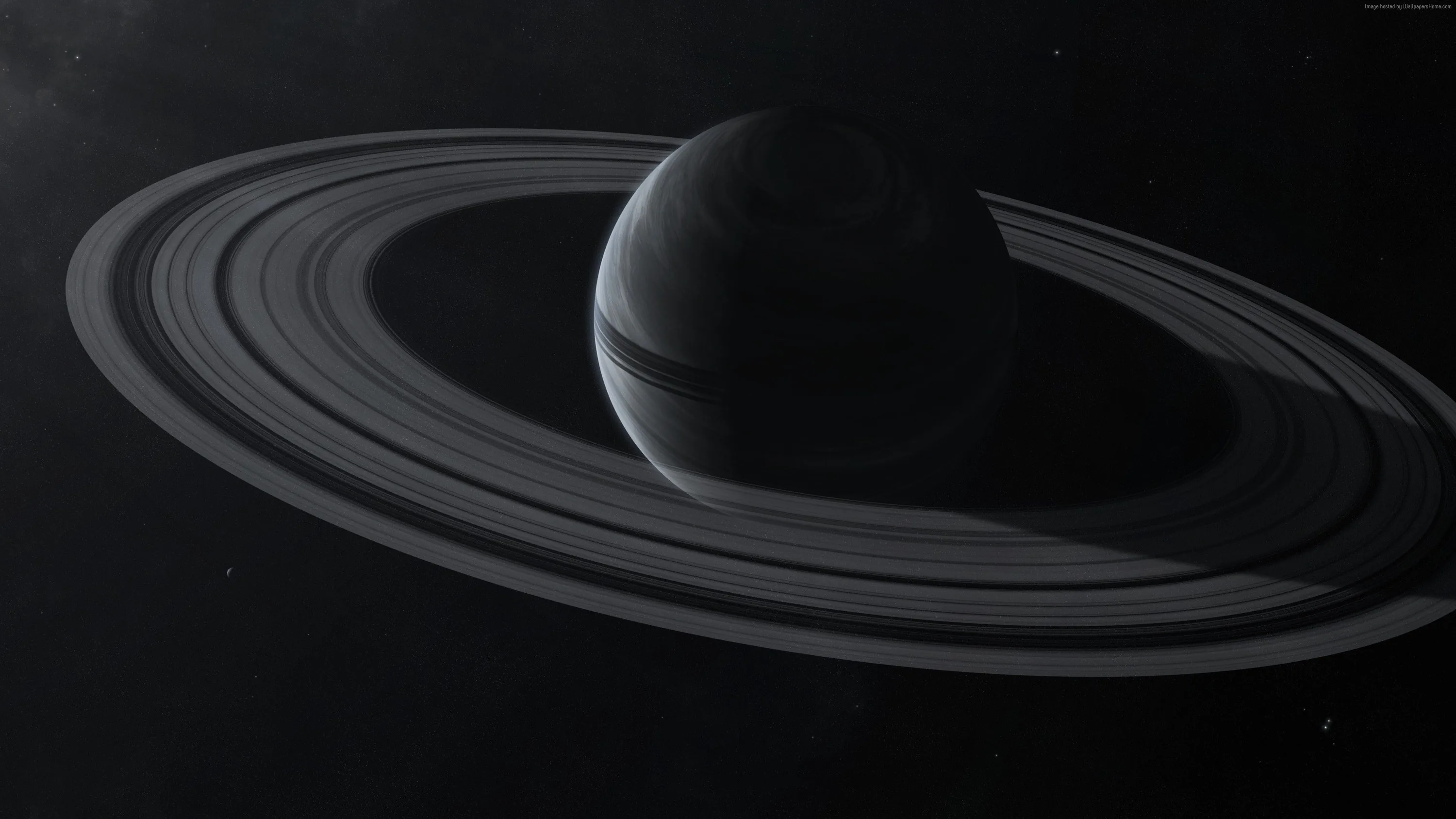 A ringed planet sits slightly left of centre, its rings cutting the frame in a wide ellipse against dark space.