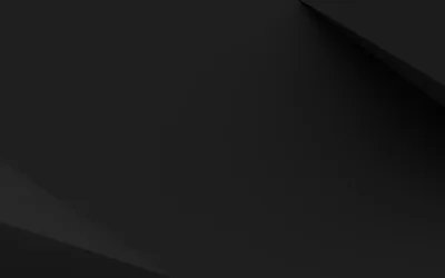 Broad diagonal creases cut across a dark grey surface, one shadowed wedge in the top right and another lifting from the bottom left.