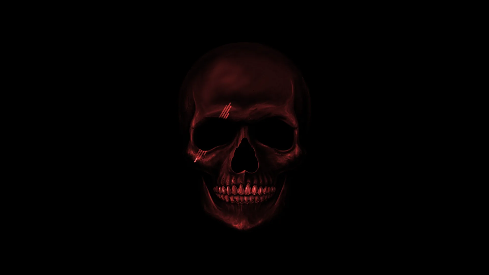 Deep red light rakes across a skull from the front, the jaw and eye sockets sinking into black with nothing else in the frame.