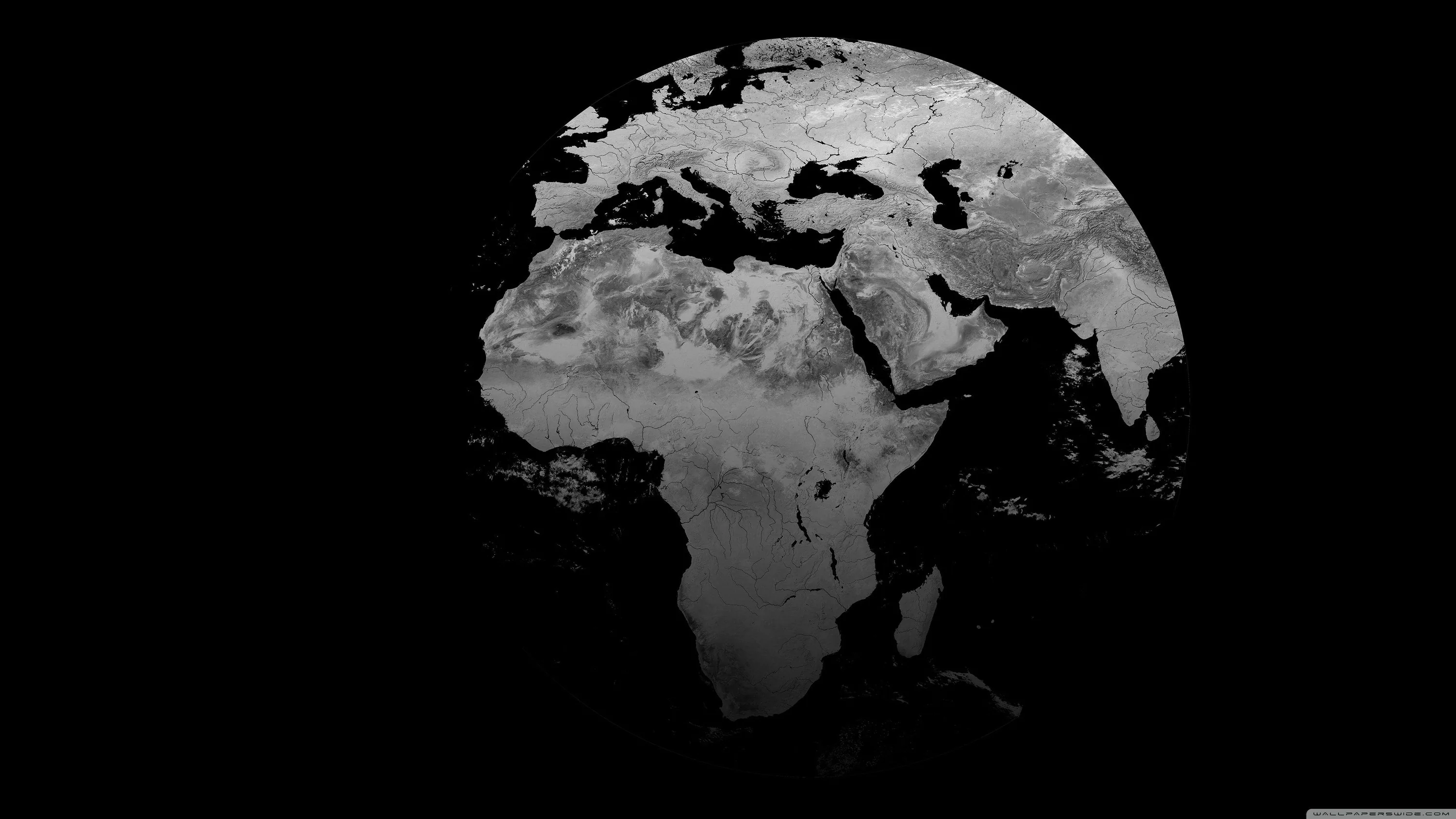 A grey-toned globe floats on solid black with Europe and Africa facing forward, the lower half breaking apart into cloud and shadow.
