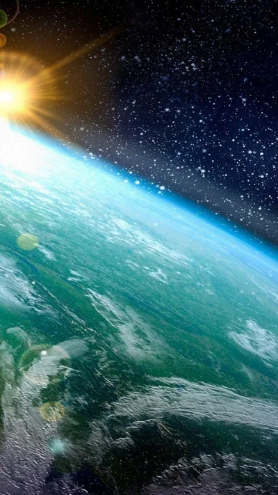 The curve of the planet cuts diagonally across a starfield with the sun flaring over the horizon, oceans and cloud lit in blue and green.