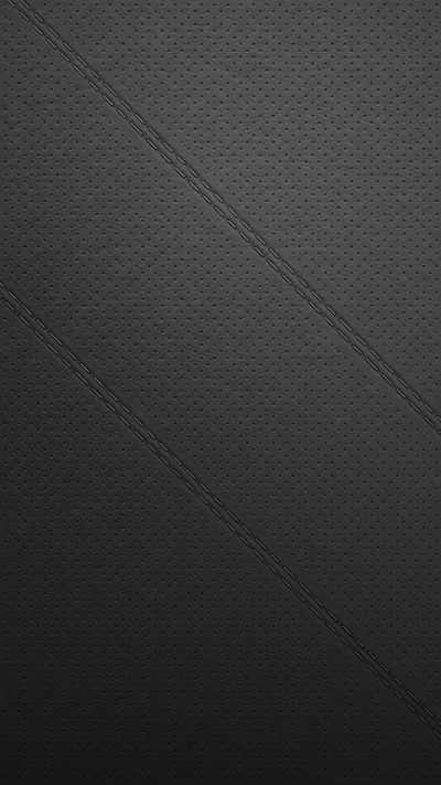 A fine diamond-quilted grain covers a charcoal surface, cut by two stitched diagonals that run from the top left corner down to the right edge.