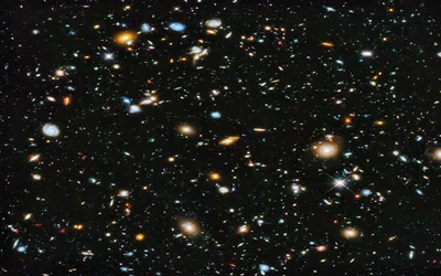 Thousands of distant galaxies scattered across a black frame in the style of a Hubble deep-field shot, with no single subject to fight your desktop icons.