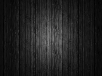 Narrow vertical boards in blackened wood run top to bottom, the grain lit softly across the middle and the sides dropped into shadow.