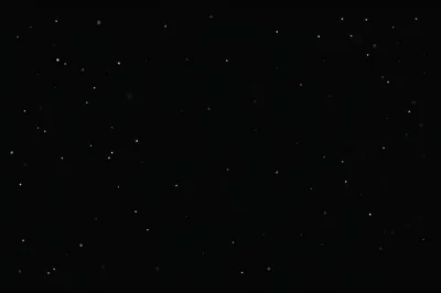 Widely spaced white stars over deep black with no cloud or horizon, the kind of empty sky that leaves room for desktop icons.