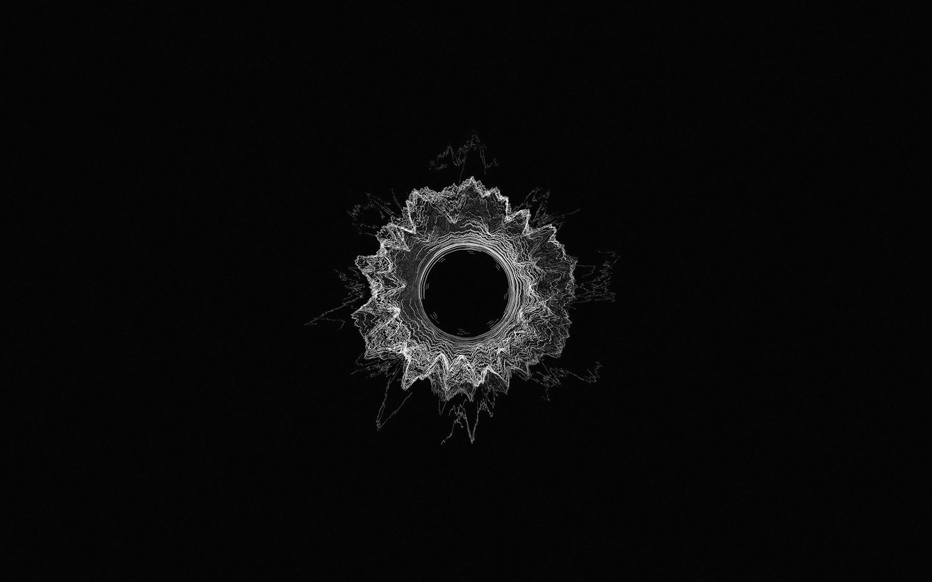 A single hole punched through dark glass, cracks radiating out in pale frost-like shards against an otherwise empty black field.