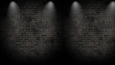 Two pairs of narrow beams wash down a dim brick wall, leaving the centre and the far edges of the frame in shadow.