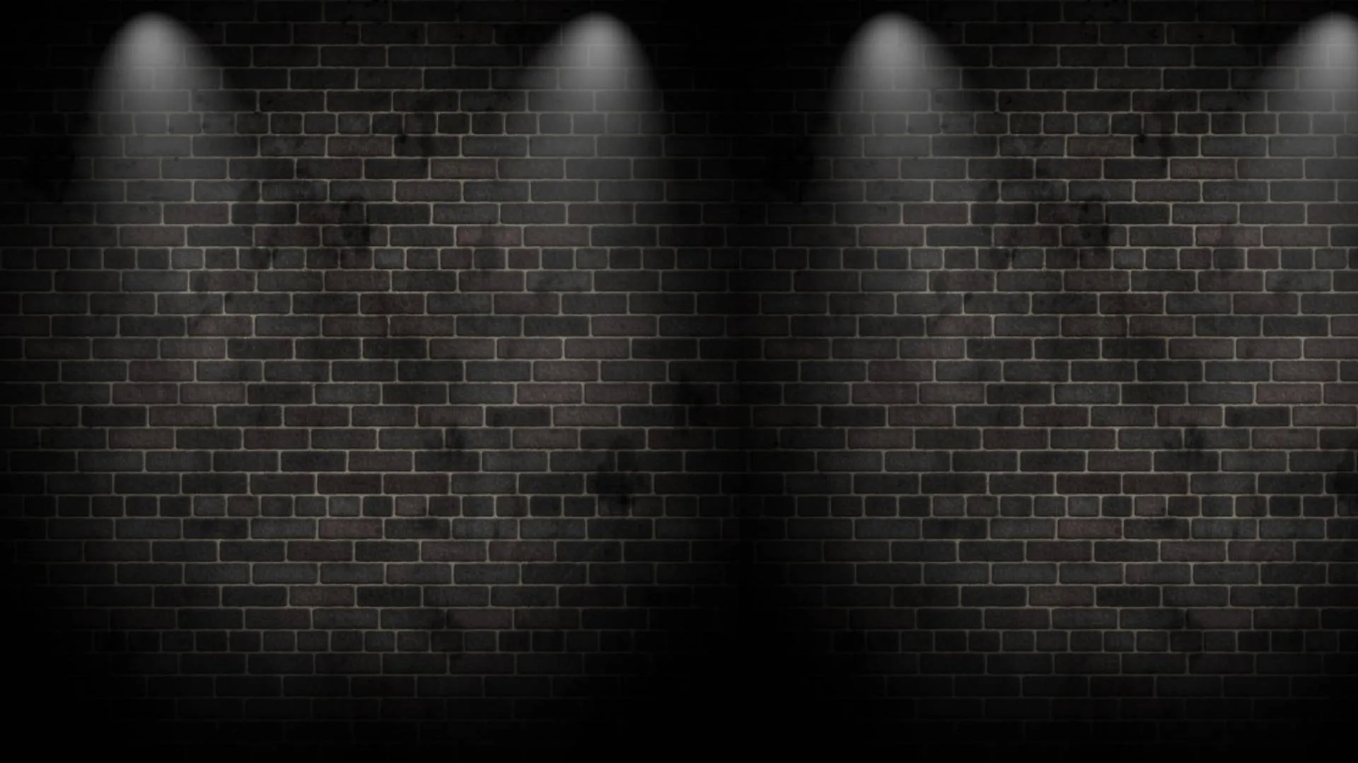 Two pairs of narrow beams wash down a dim brick wall, leaving the centre and the far edges of the frame in shadow.