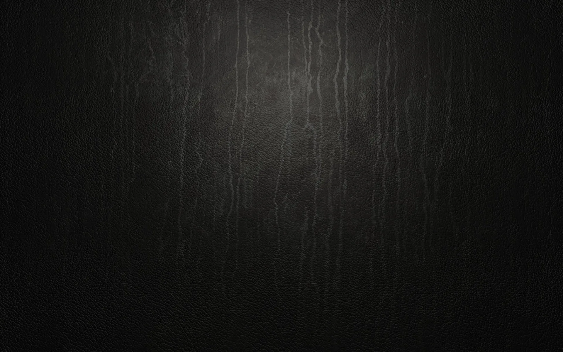 Vertical scratches and drip marks run down a matte black wall, caught by a dim light from above that leaves the lower corners in near total darkness.