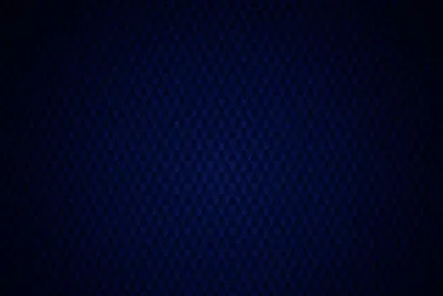 Faint quilted diamonds texture a dark navy ground, the pattern visible only near the lit centre before every corner slips into plain black.