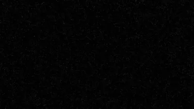 A flat black frame carrying nothing but fine grain, the noise showing only where it thins along the top edge.