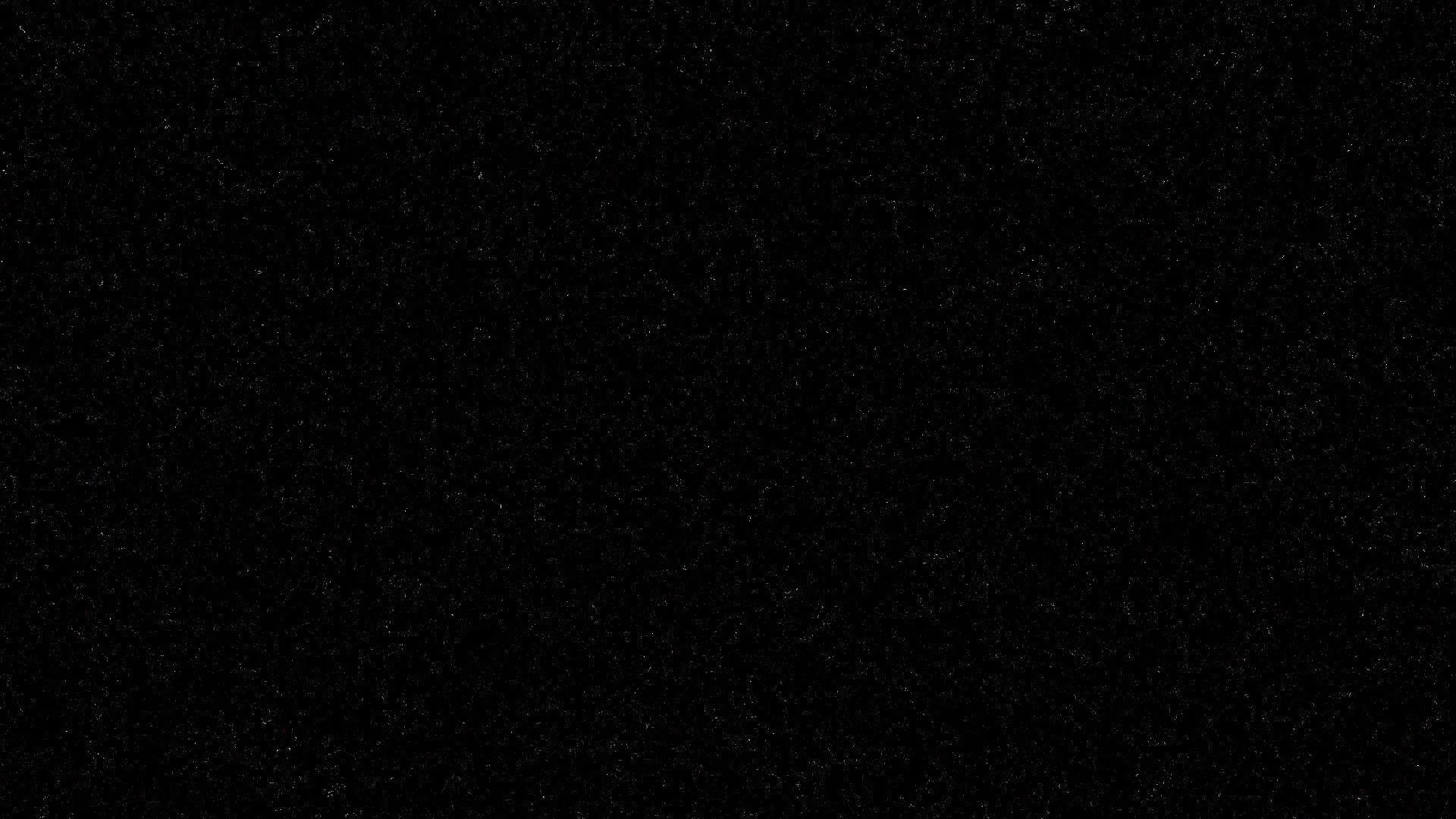 A flat black frame carrying nothing but fine grain, the noise showing only where it thins along the top edge.