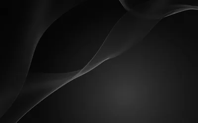 Gentle folds of dark material cross the upper half of the frame, the light grazing them and leaving the base plain.