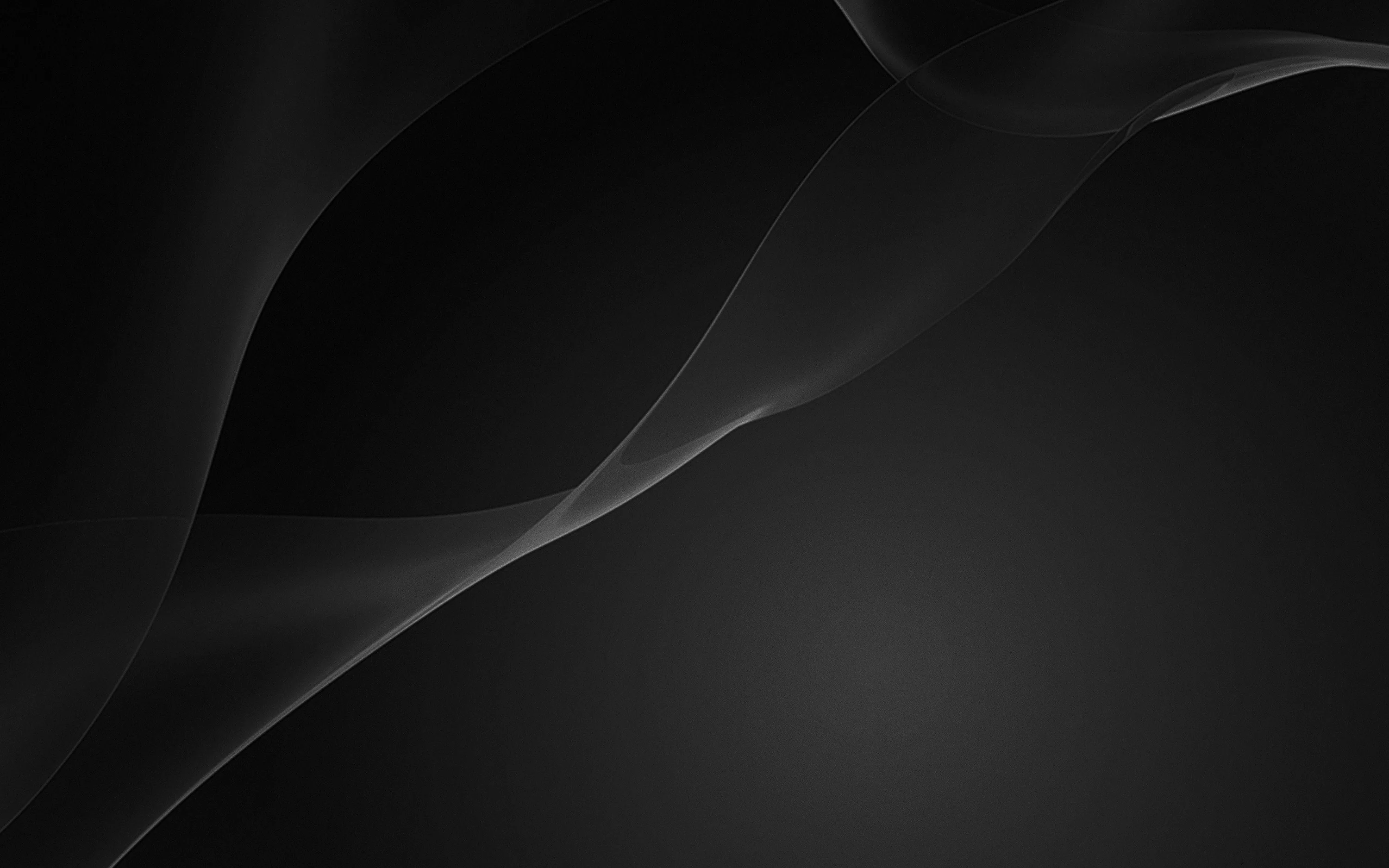 Gentle folds of dark material cross the upper half of the frame, the light grazing them and leaving the base plain.