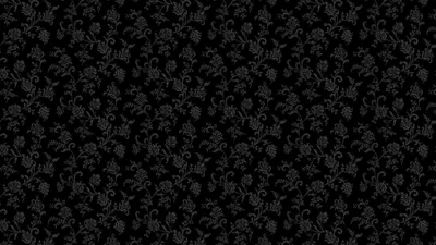A repeating floral damask sits barely a shade above the black ground, visible only where the light catches the raised print.