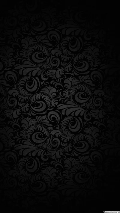 Ornate scrollwork repeats edge to edge in a barely lighter black, readable only where a dim glow catches the raised curls at the centre.