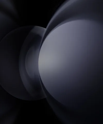 Two large spheres overlap in near-darkness, the closer one lit by a cool grey sheen along its upper edge — the left third stays black for icons.