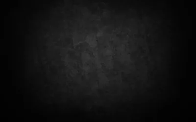 A worn plaster wall in charcoal with patchy stains across the middle, the vignette pulling all four corners down to black.