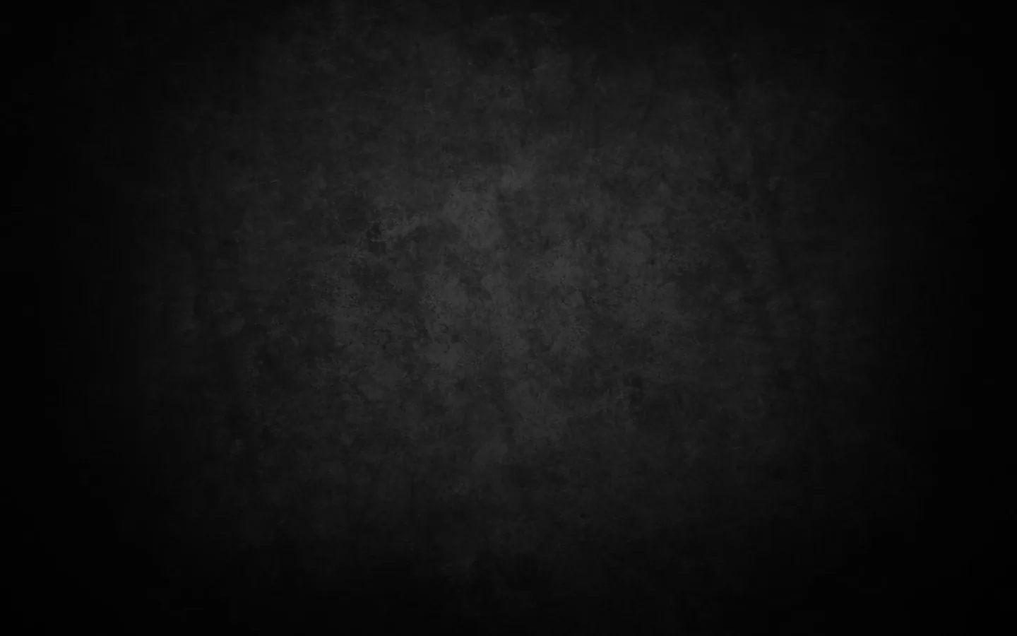 A worn plaster wall in charcoal with patchy stains across the middle, the vignette pulling all four corners down to black.