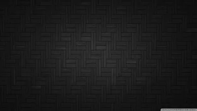 Small rectangular tiles laid in a herringbone weave fill the frame, the light lifting through the centre and the grout lines fading to black at the edges.
