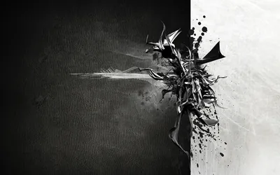 A burst of dark shards erupts along the seam where a black half meets a white one — half lit, half swallowed.
