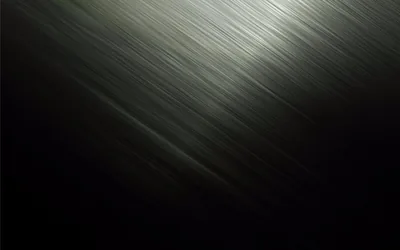 A band of brushed metal catches light diagonally through the frame, the rest falling into flat dark grey.