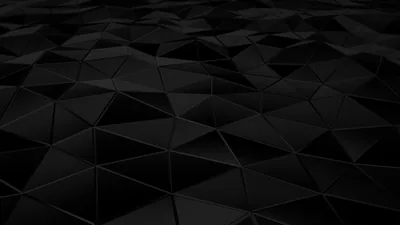 A field of dark triangular facets tilts away toward the horizon, each panel catching a different grey.