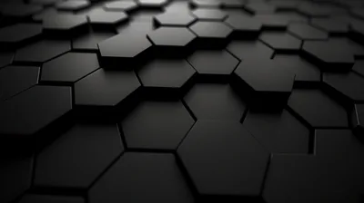 Matte black hexagons sit at slightly different heights, their edges picking up a low raking light.