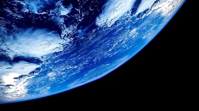 A saturated blue curve with swirling white cloud crosses the frame diagonally, leaving the lower right corner in pure black for icons or a dock.