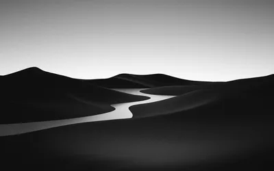 A pale river winds between smooth black dunes under a plain grey sky in a minimal monochrome scene.