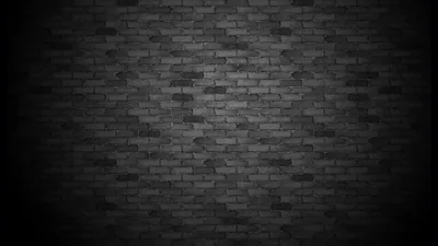 A soft pool of light lands in the middle of a grey brick wall and falls away to black at both sides, leaving the corners empty for icons.