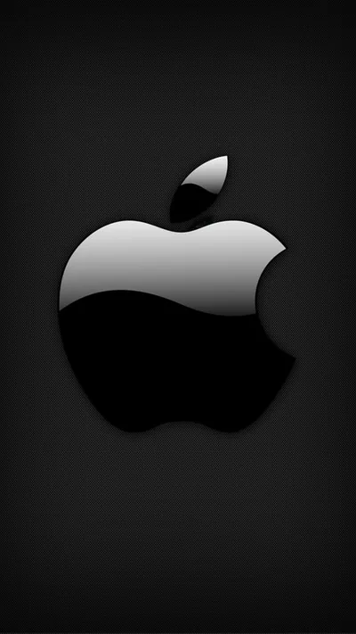 A polished silver Apple logo catches a single broad reflection across its upper half, set on a black background that fades at the corners.