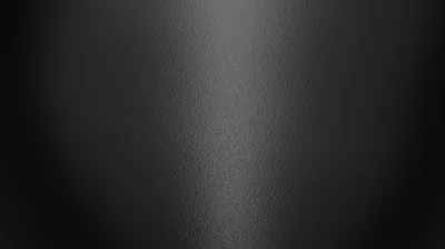 A faint column of light falls down the centre of finely grained matte black, both side edges staying dark for OLED screens.