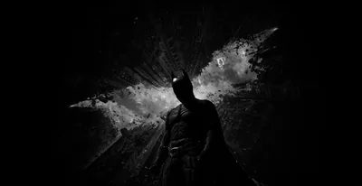 A caped figure stands in silhouette while a cracked bat symbol glows across the wall behind him.