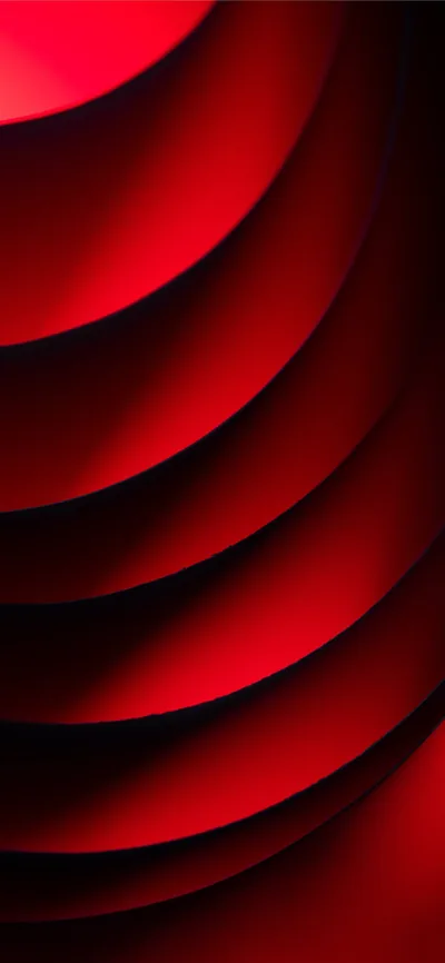 Curved red sheets stack one behind another in close-up, the shadow deepening in every fold toward the left side of the frame.