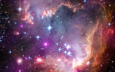 Young star clusters blaze white inside pink and violet nebula walls, an orange arc of dust curling down the right side.