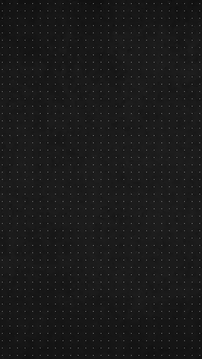 A dense grid of pinpoint dots covers a charcoal surface edge to edge, even enough that nothing pulls the eye to one spot.