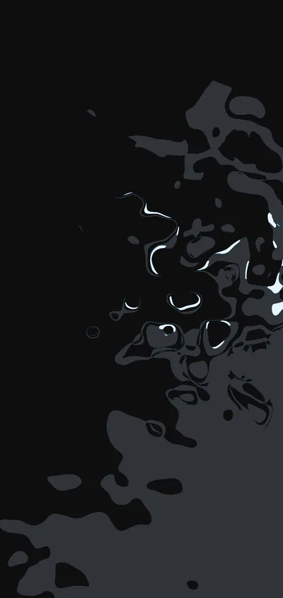 Black liquid spreads over a reflective dark surface, the highlights along its edges the only thing separating it from the background.