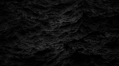 Sharp black rock fills the frame, its ridges catching just enough light to separate from the shadow between them.