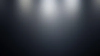 Three faint pools of white light spill from the top edge of a smooth blue-grey surface, the bottom half falling dark enough for icons and text.