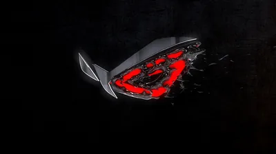The ROG eye breaks apart into shards on solid black, red light bleeding out of the fractures on the right half.