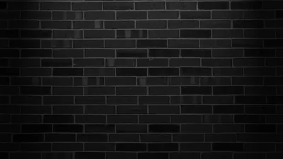 Smooth dark bricks laid in even courses, a wash of light across the upper half leaving the bottom edge in shadow.