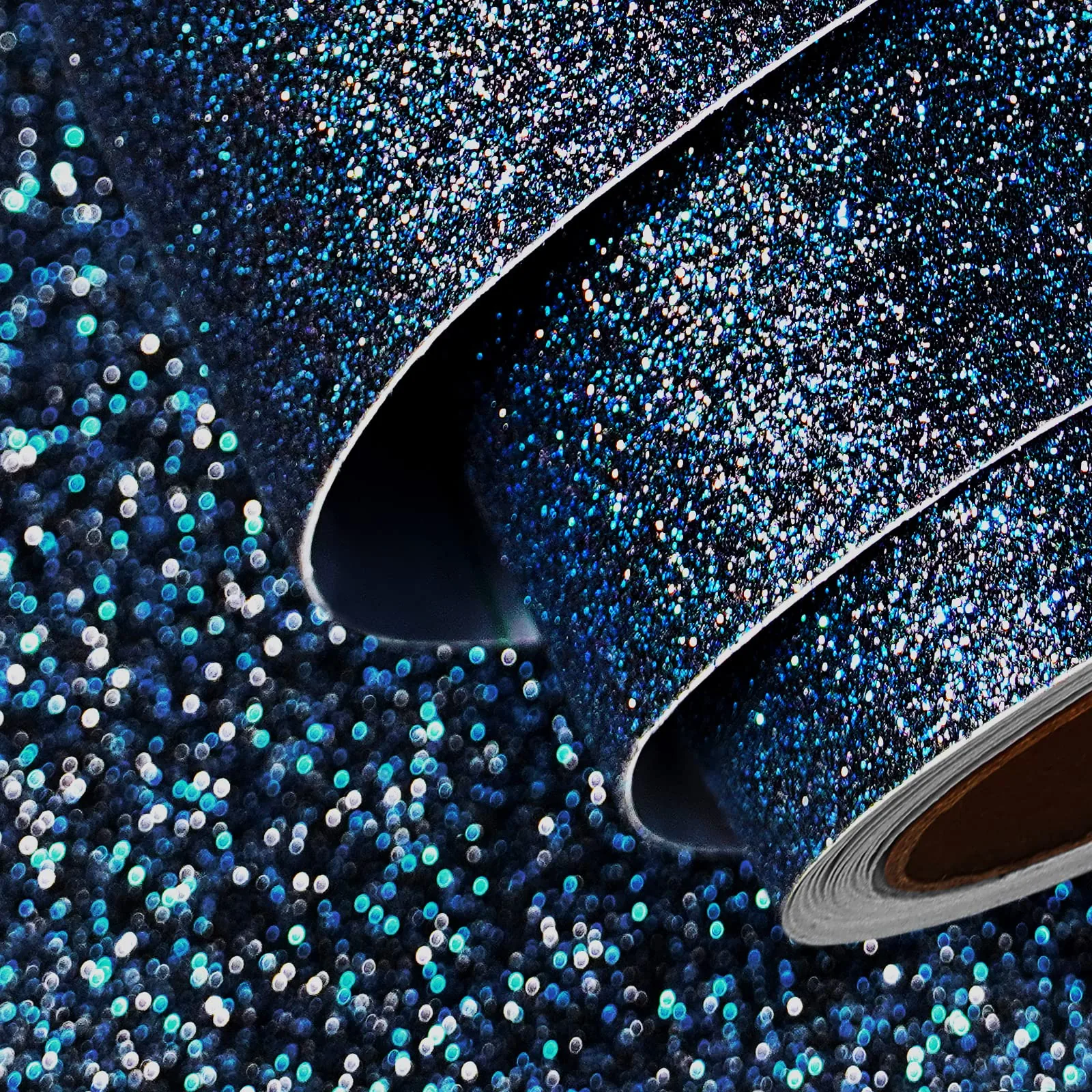 Rolled sheets of peel-and-stick glitter material catch the light, dense navy sparkle broken up by scattered teal and silver flecks, sharpest in the lower left.