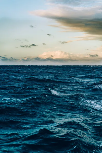 Choppy navy water fills the lower two thirds while dusk clouds sit at the horizon, leaving the darker sky clear for widgets.