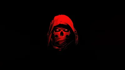 A skull face under a hood, lit only in deep red, sitting small and centred in an otherwise completely black frame.