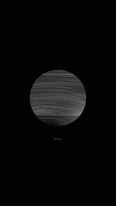 A single sphere banded with fine wind-blown streaks hangs just above centre, everything around it true black, so the dock and bottom half stay completely empty.