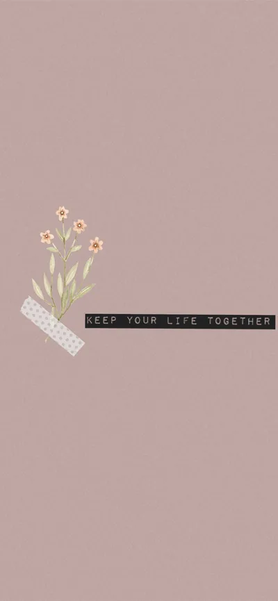 A taped flower sprig and a small black label reading keep your life together sit left of centre on an otherwise plain dusty pink field.
